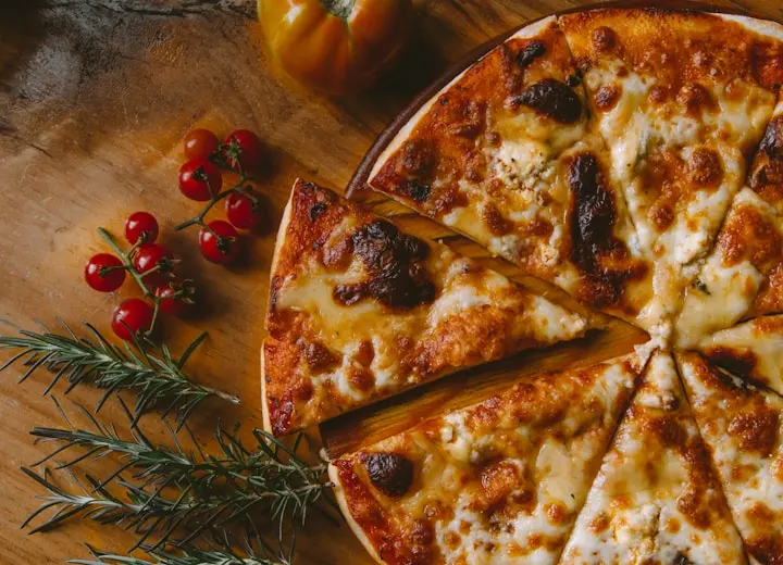 Pizza de queijo servida em mesa de madeira