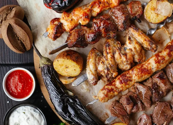 Espetinhos de carnes assadas com acompanhamentos
